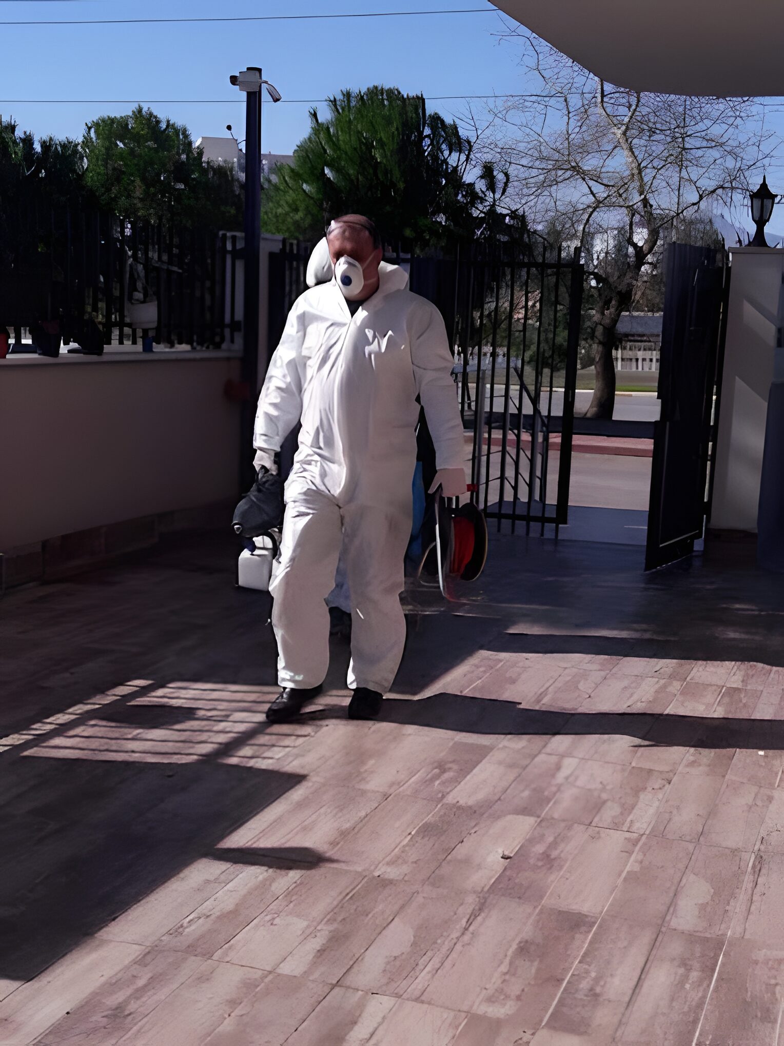Dış alanda koruyucu kıyafetli haşere kontrol teknisyeni